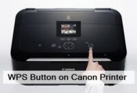 Close-up image of a finger activating the WPS button on a Canon printer for a wireless connection.